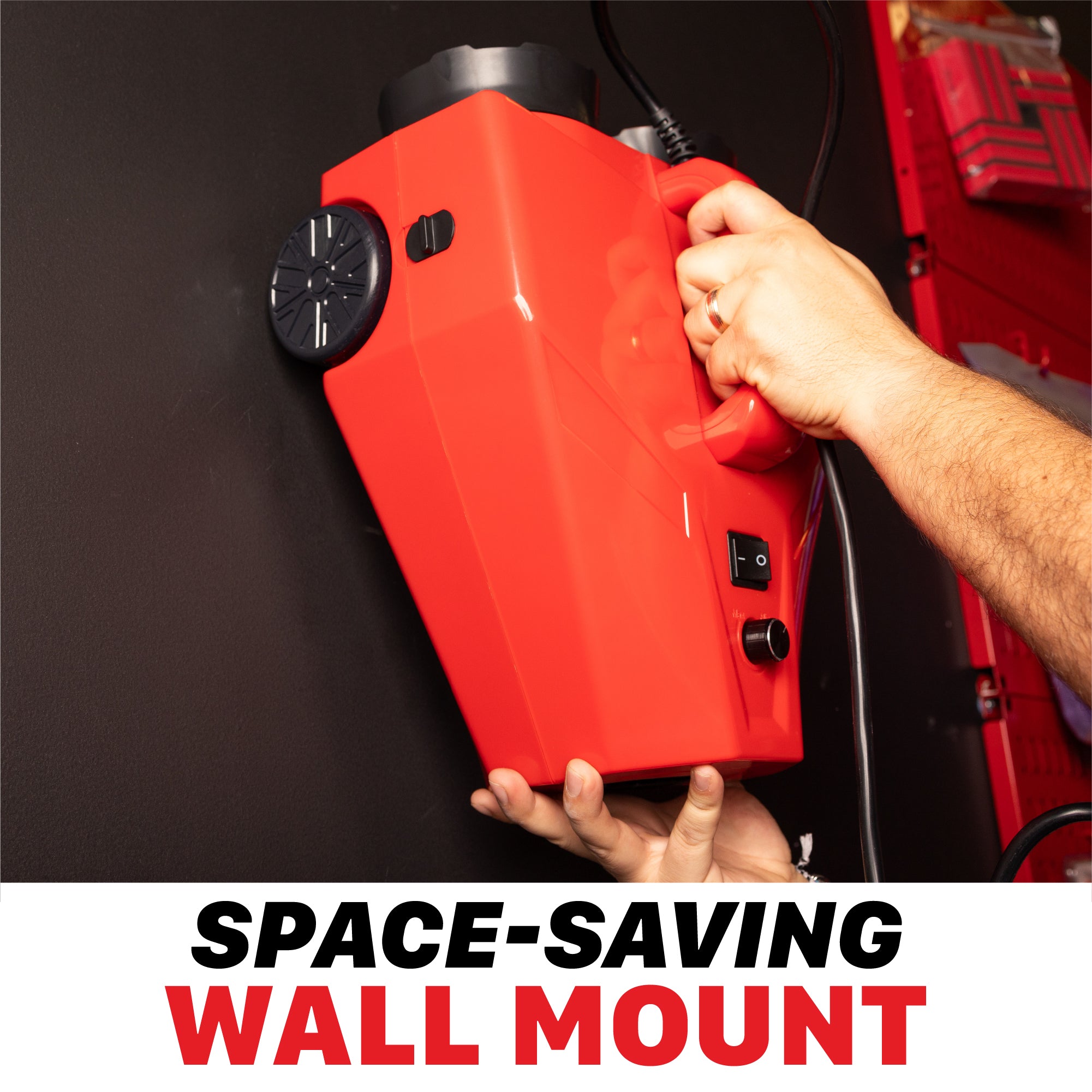 A bright red wall-mounted car dryer holder being held by two hands against a dark wall, with a bold text overlay at the bottom reading 'SPACE-SAVING WALL MOUNT'. H16 H17 Touchless Car Dryer Wall Mounts