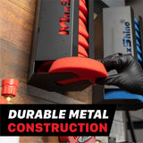 A black MaxShine polishing pads wall mount filled with red foam pads, shown with a gloved hand holding the foam pad. The background is a wooden surface with other MaxShine bottles, and a text overlay at the bottom reads 'DURABLE METAL CONSTRUCTION'. Polisher Pads Holders