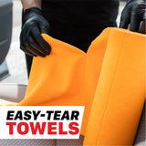 A person wearing black gloves holds open a bright orange towel, with a white text box at the bottom reading 'EASY-TEAR TOWELS'. 1103030 260GSM Microfiber Tear-Away Towel Roll